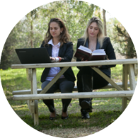 סטודנטיות לומדות על ספסל בחצר הקמפוס