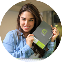 סטודנטית מחייכת עם מחברת ביד