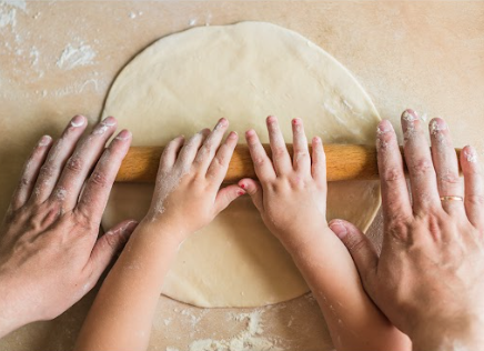 Children and dad hands rolled dough